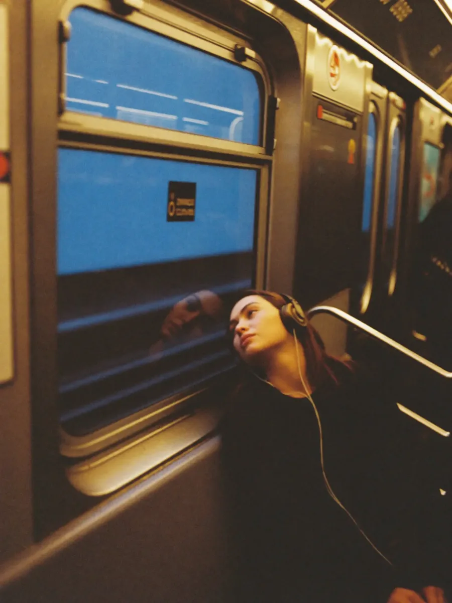 A commuter with headphones on the train